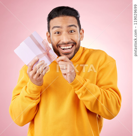 Young man, gift box and studio portrait with excited smile, ribbon and open for celebration by pink background. Asian gen z student, present or prize for giveaway, competition or package for party Young man, gift box and studio portrait with excited smile, ribbon and open for celebration by pink background. Asian gen z student, present or prize for giveaway, competition or package for party 119029699