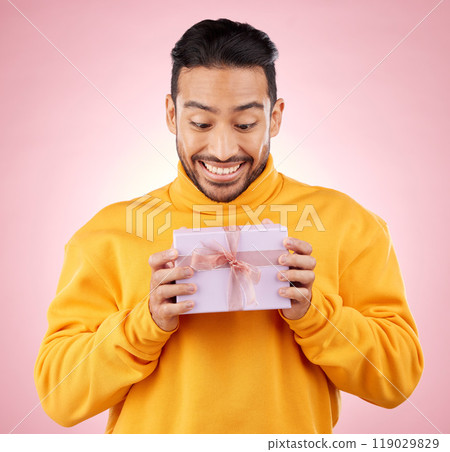 Man, winner and excited for gift box, prize and giveaway celebration or birthday surprise on pink background. Happy person with present, package and retail shopping or competition success in studio Man, winner and excited for gift box, prize and giveaway celebration or birthday surprise on pink background. Happy person with present, package and retail shopping or competition success in studio 119029829