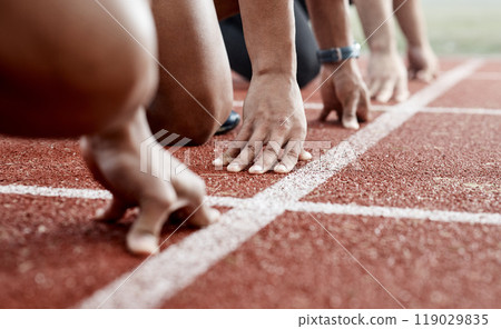 Ground, hands and people ready for a race, running competition or training at a stadium. Fitness, sports and athlete runners in a line to start a sprint, exercise or challenge in track or athletics 119029835