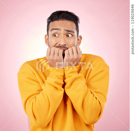 Anxiety, thinking and asian man biting nails in studio with terror, fear and scared for drama on pink background. Stress, gossip and wtf by male person with horror, fake news or worried about secret 119029846