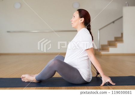 Pregnant woman is engaged in yoga. Butterfly Pose or Baddha Konasana Pregnant woman is engaged in yoga. Butterfly Pose or Baddha Konasana 119030081