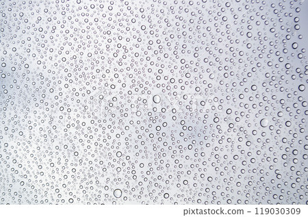 Close-up of droplets clustering on a glass surface after rain. Water texture concept 119030309