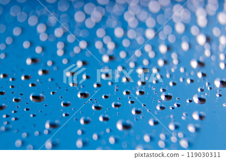 Side view of tiny water droplets on a clear blue background. Rain patterns concept 119030311