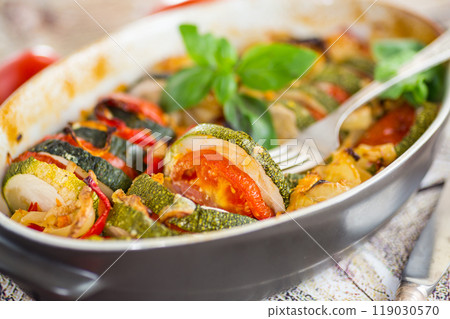 prepared baked zucchini and tomatoes in circles in a ceramic form, vegetable snack prepared baked zucchini and tomatoes in circles in a ceramic form, vegetable snack 119030570