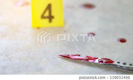 A bloodstained stainless steel knife lying on a concrete floor, with a blurred yellow number 4 sign nearby and blood splatter surrounding the scene, evoking a sense of crime investigation. 119031498
