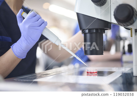 Embryologist using a microscope in the incubation lab 119032038