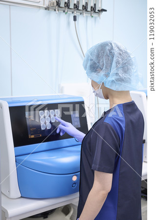 Embryologist observing fertilized eggs in an incubator Embryologist observing fertilized eggs in an incubator 119032053