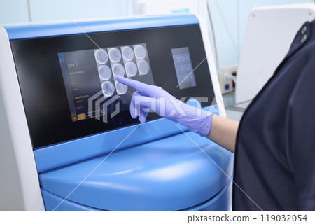 Embryologist observing fertilized eggs in an incubator Embryologist observing fertilized eggs in an incubator 119032054