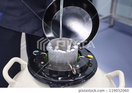 An experimenter managing samples in a liquid nitrogen tank An experimenter managing samples in a liquid nitrogen tank 119032060
