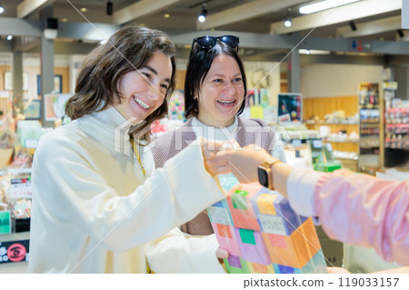 Foreign tourists paying at the cash register 119033157