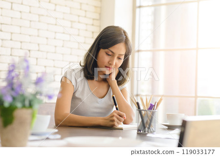 Beautiful asian businesswoman wear casual clothing while sitting in modern kitchen near window, working with computer laptop at home. Work at home concept. 119033177
