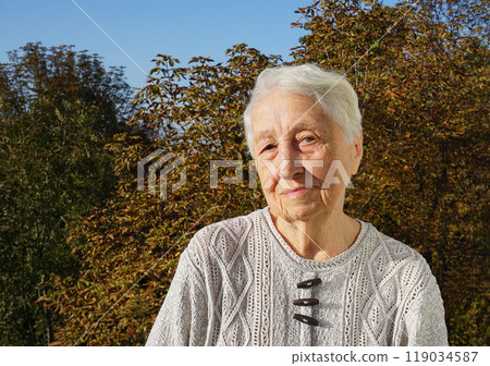 Portrait of sad senior woman posing in autumn park Portrait of sad senior woman posing in autumn park 119034587