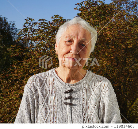 Portrait of sad senior woman posing in autumn park Portrait of sad senior woman posing in autumn park 119034603