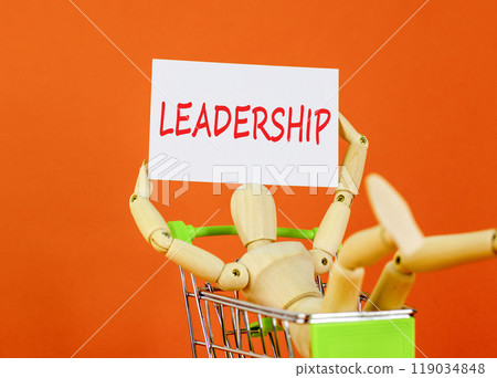 Leadership symbol. Concept word Leadership on beautiful white paper. Beautiful orange background. Businessman model in shop cart. Business leadership concept. Copy space. 119034848