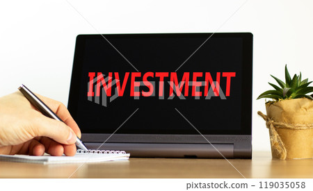 Investment symbol. Concept word Investment on beautiful black tablet. Beautiful wooden table white background. Businessman hand with pen. Business investment concept. Copy space. Investment symbol. Concept word Investment on beautiful black tablet. Beautiful wooden table white background. Businessman hand with pen. Business investment concept. Copy space. 119035058