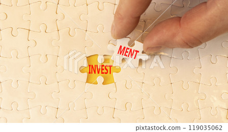 Investment symbol. Concept word Investment on beautiful white puzzles. Beautiful yellow background. Businessman hand. Business investment concept. Copy space. 119035062