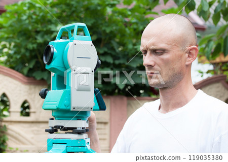 A man works with a total station device 119035380