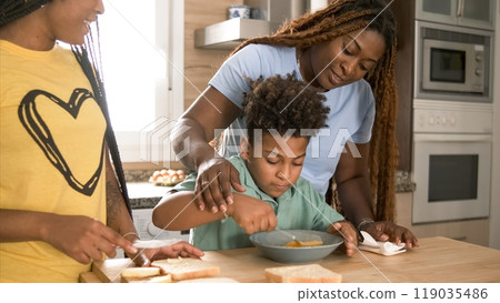 Happy mother assisting son in mixing egg yolk with daughter in kitchen Happy mother assisting son in mixing egg yolk with daughter in kitchen 119035486