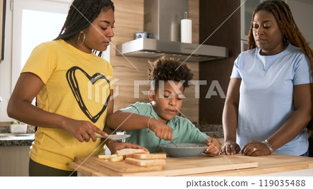 Happy mother assisting son in mixing egg yolk with daughter in kitchen Happy mother assisting son in mixing egg yolk with daughter in kitchen 119035488
