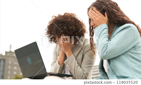 Sad female entrepreneurs with netbook under sky outdoors Sad female entrepreneurs with netbook under sky outdoors 119035520