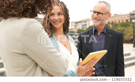 Happy business executives using tablet in city 119035552