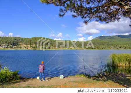 Man relaxing by fishing near the lake  in countryside 119035621