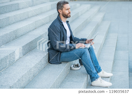 man blogging online in the street. man blogging online with pc outside. man blogging online in the street. man blogging online with pc outside. 119035637