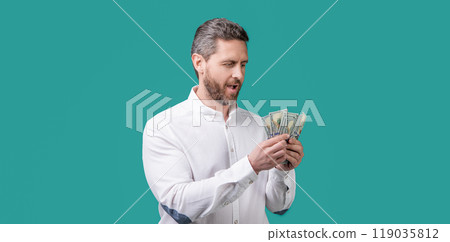 amazed businessman earning money in studio. businessman hold money earning 119035812