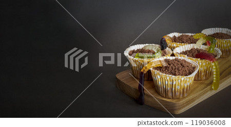 Cupcakes with edible jelly worms for Halloween celebration stand ready to be eaten, copy space 119036008