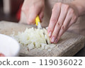 Woman's hands cutting an onion into pieces close-up. The process of preparing seasoning for meat. 119036022