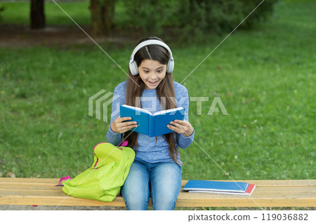 School amazed girl read book and listen audiobook outdoor. Back to school. Education and knowledge. Girl listen audiobook and read book. Audiobook vs book. Student girl. School education 119036882