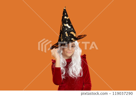 Girl in Halloween witch costume. Happy Halloween. Girl witch in Halloween costume isolated on orange. Trick or treat. All Hallows costume party celebration. All Hallows witch. Magical aura Girl in Halloween witch costume. Happy Halloween. Girl witch in Halloween costume isolated on orange. Trick or treat. All Hallows costume party celebration. All Hallows witch. Magical aura 119037290