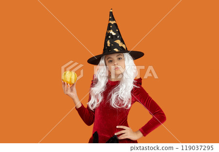 October 31 pumpkin. Costume party. Halloween pumpkin in hand of witch girl. Halloween witch girl isolated on orange. Pumpkin on Halloween. Witch Hallows costume of girl. Traditional Halloween symbol October 31 pumpkin. Costume party. Halloween pumpkin in hand of witch girl. Halloween witch girl isolated on orange. Pumpkin on Halloween. Witch Hallows costume of girl. Traditional Halloween symbol 119037295