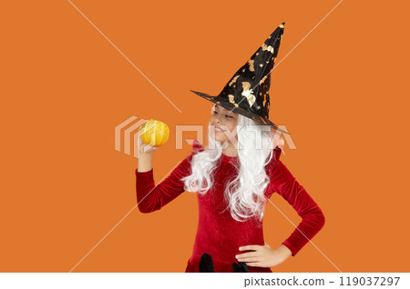 Halloween witch girl isolated on orange. Pumpkin on Halloween. Witch All Hallows costume of girl. October 31 pumpkin. Costume party. Halloween pumpkin in hand of witch girl. Halloween decoration Halloween witch girl isolated on orange. Pumpkin on Halloween. Witch All Hallows costume of girl. October 31 pumpkin. Costume party. Halloween pumpkin in hand of witch girl. Halloween decoration 119037297