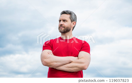 man in red shirt outdoor on sky background. confidence 119037823