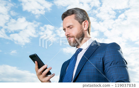 businessman type phone message on sky background outdoor. businessman type phone message on sky background outdoor. 119037838