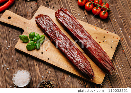 Dry-cured salami on board, ideal for rustic charcuterie presentations and gourmet food styling 119038261