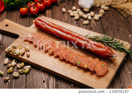 Sliced gourmet salami with pistachios on board with herbs, perfect for charcuterie boards and snacks Sliced gourmet salami with pistachios on board with herbs, perfect for charcuterie boards and snacks 119038287