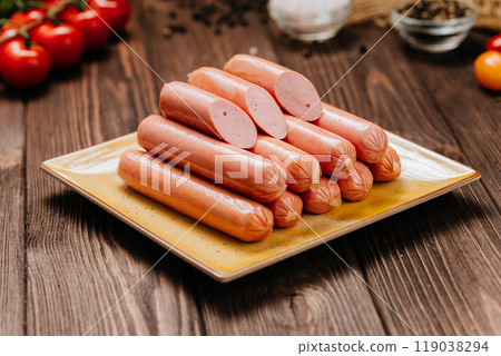 Stack of sausages on plate, ideal for BBQ, grilling, or quick meals, displayed in a kitchen setting Stack of sausages on plate, ideal for BBQ, grilling, or quick meals, displayed in a kitchen setting 119038294