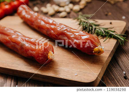 Smoked salami sticks on a wooden board with herbs, perfect for charcuterie boards and gourmet snacks Smoked salami sticks on a wooden board with herbs, perfect for charcuterie boards and gourmet snacks 119038298