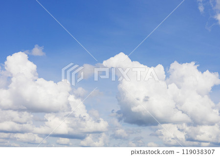 The sky is a beautiful shade of blue adorned with white clouds in it 119038307