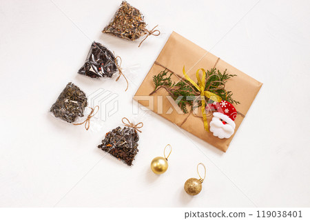 New year flat lay. Christmas tea gift box wrapped in kraft paper with pine tree cones.Mockup template. Winter holidays 119038401