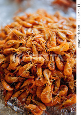 Fresh shrimp on ice, perfect for seafood markets, food photography, or culinary presentation 119038911