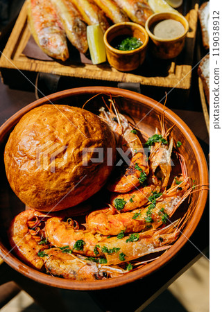 Grilled prawns with freshly baked bread in bowl, ideal for seafood lovers and restaurant menus 119038912