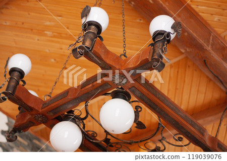 an ancient massive chandelier on the background of a wooden ceiling an ancient massive chandelier on the background of a wooden ceiling 119039076