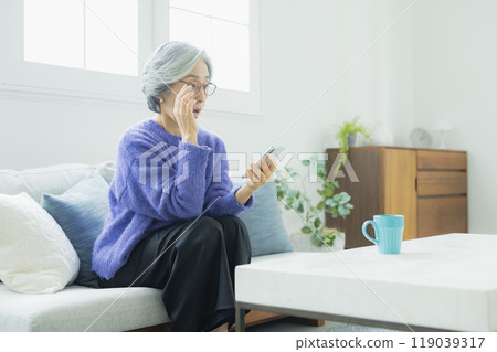 一位身穿針織品的高級女性在客廳放鬆 119039317
