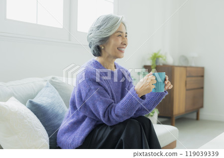 一位身穿針織品的高級女性在客廳放鬆 119039339