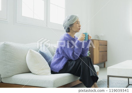 一位身穿針織品的高級女性在客廳放鬆 119039341