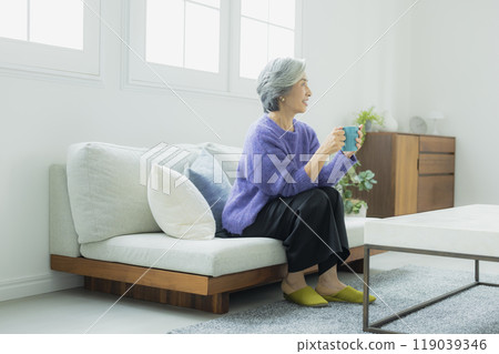 一位身穿針織品的高級女性在客廳放鬆 119039346