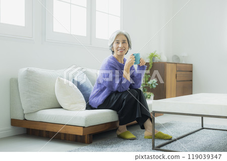 一位身穿針織品的高級女性在客廳放鬆 119039347